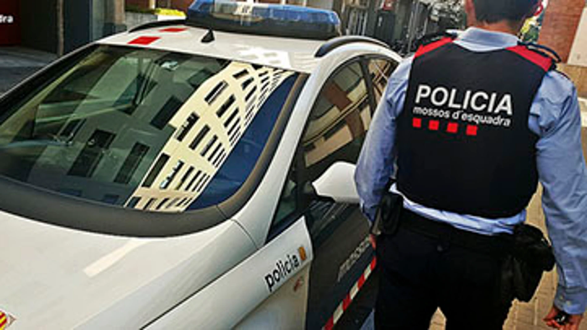 Imagen de archivo de un coche y un agente de los Mossos d'Esquadra Imagen de archivo de un coche y un agente de los Mossos d'Esquadra
